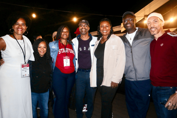 Black Stanford alumni stand together for a picture at the Black House at a House Party.